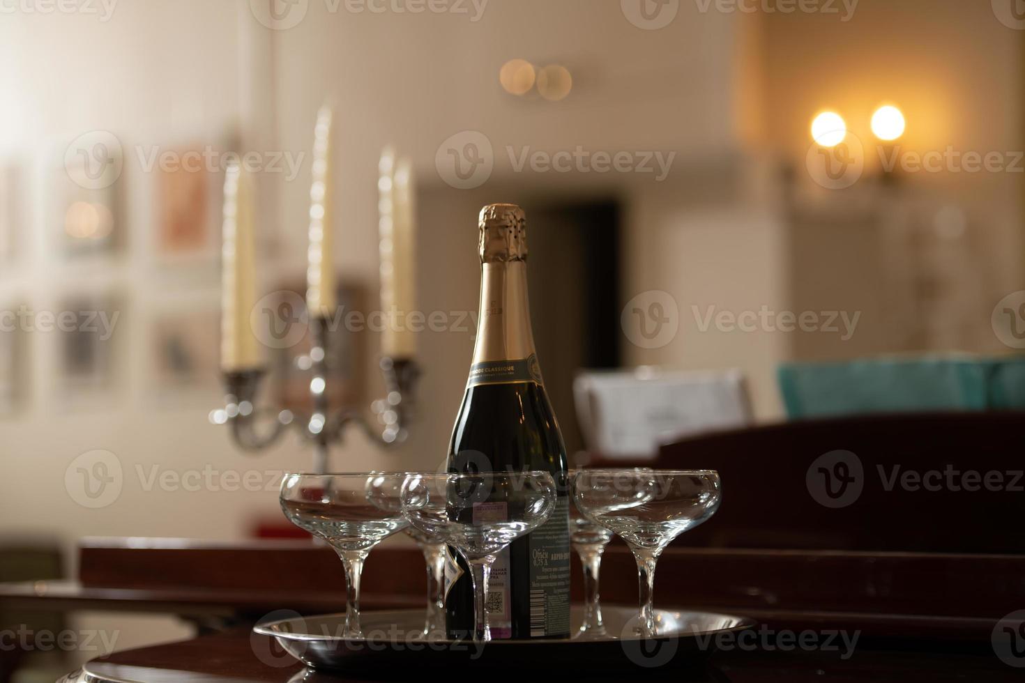 A tray with glasses of champagne and a bottle of sparkling wine. photo