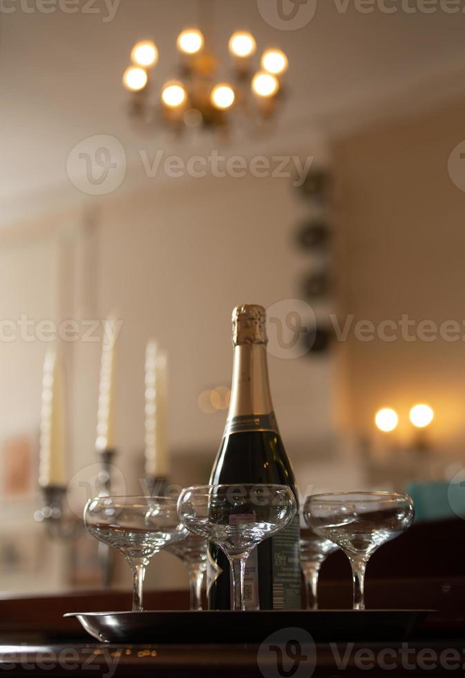 A tray with glasses of champagne and a bottle of sparkling wine. photo