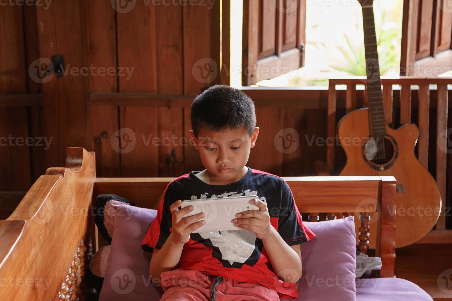 el niño jugaba con la tableta en casa. foto