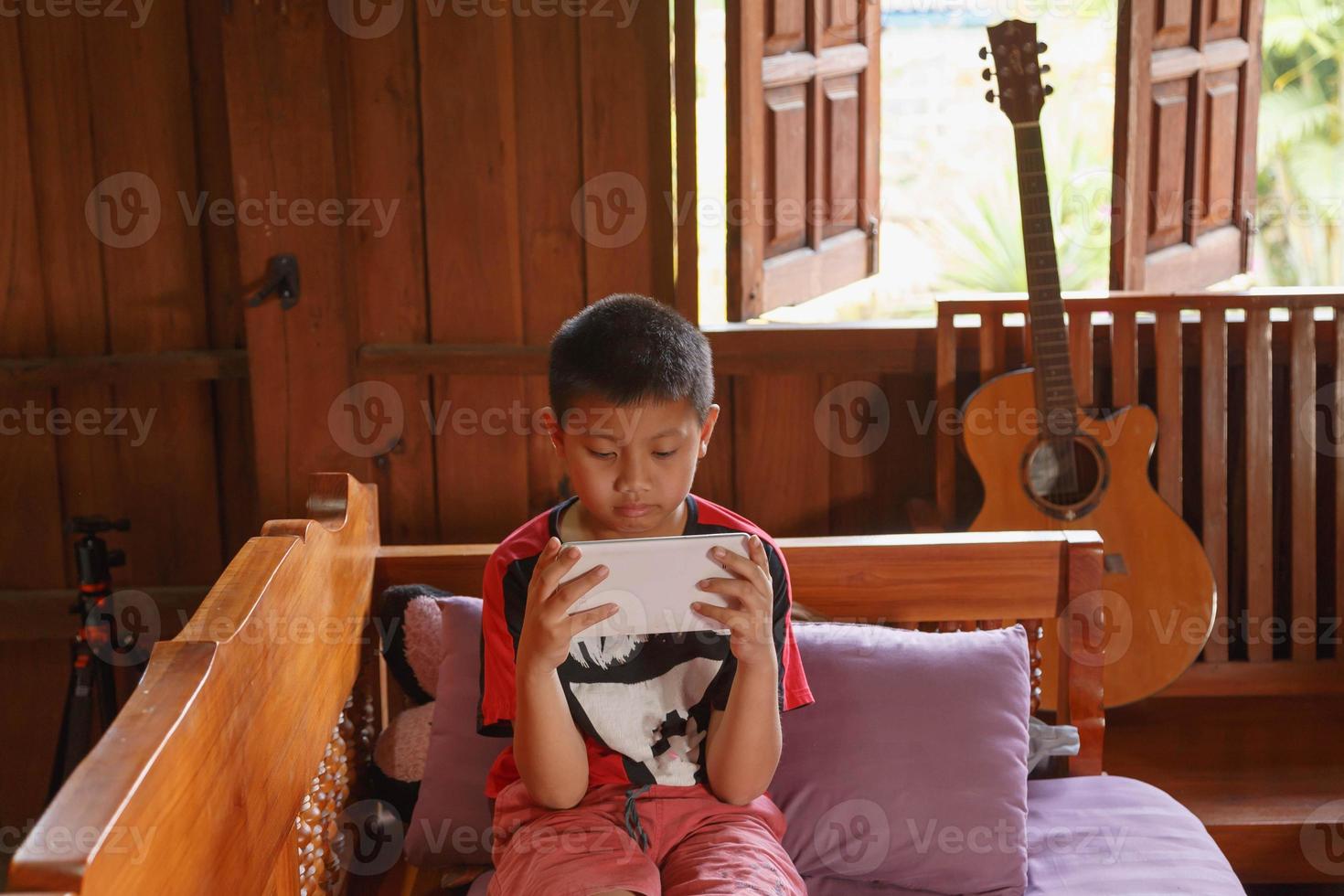 el niño jugaba con la tableta en casa. foto