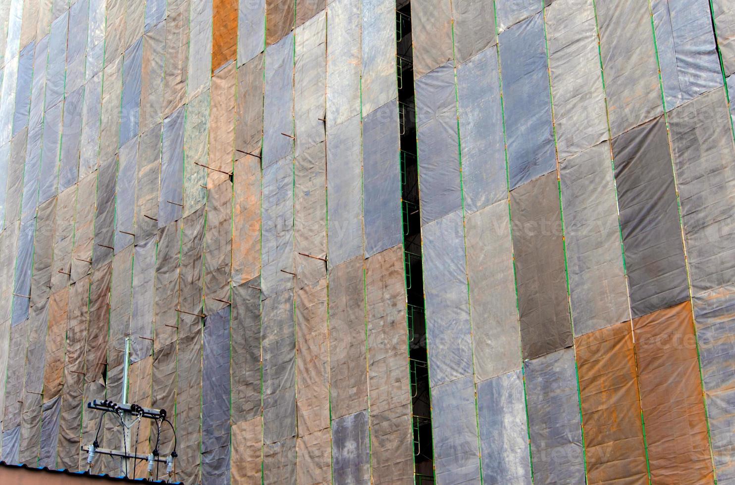 Several large canvases stretch together, Covered building under construction photo