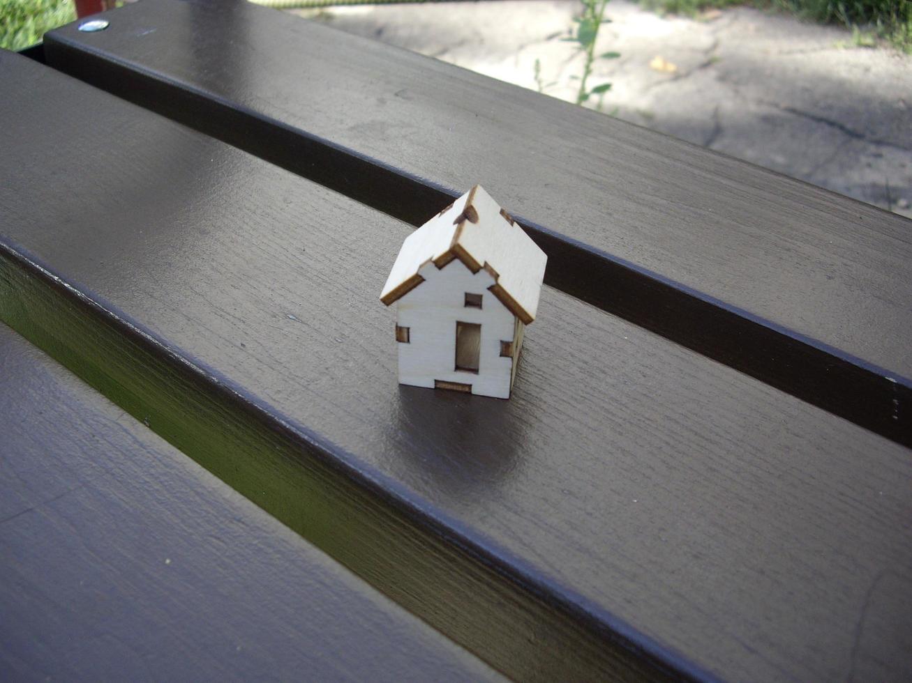 Wooden house stands on a bench photo