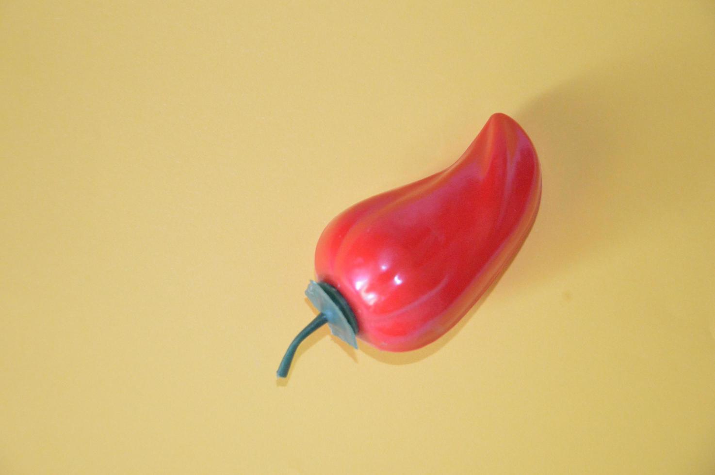 Red plastic isolated bell pepper on background photo