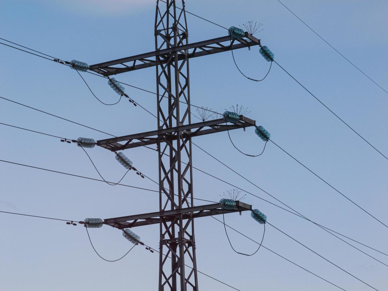 Electrical high-voltage power lines and towers on blue sky background photo