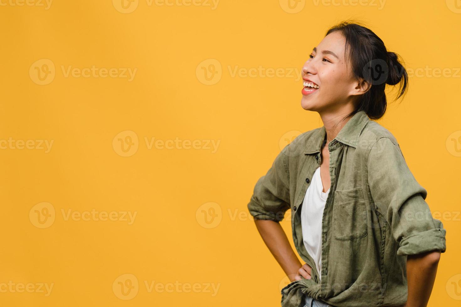 Retrato de joven asiática con expresión positiva, sonrisa amplia, vestida con ropa casual sobre fondo amarillo. feliz adorable mujer alegre se regocija con el éxito. concepto de expresión facial. foto