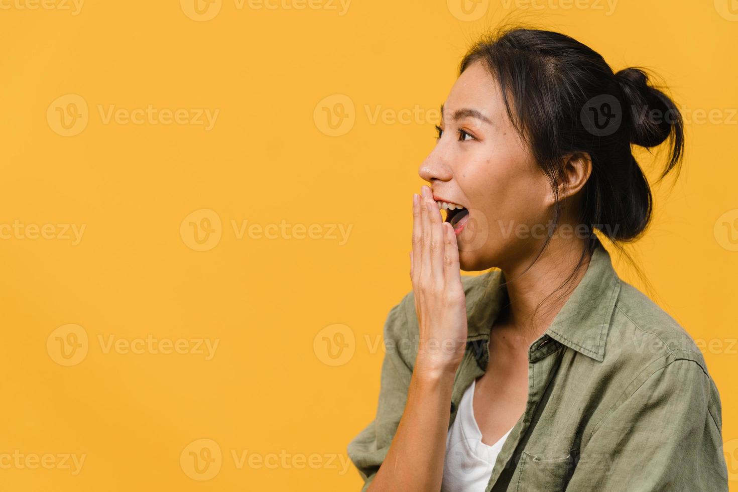 Young Asia lady feel happiness with positive expression, joyful surprise funky, dressed in casual cloth isolated on yellow background. Happy adorable glad woman rejoices success. Facial expression. photo