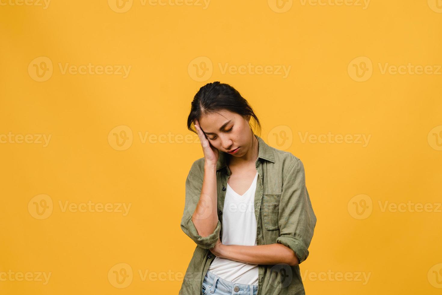Portrait of young Asia lady with negative expression, excited screaming, crying emotional angry in casual clothing isolated on yellow background with blank copy space. Facial expression concept. photo