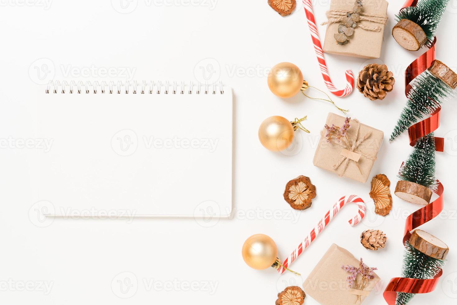 Minimal creative flat lay of winter christmas traditional composition and new year holiday season. Top view open mockup black notebook for text on white background. Mock up and copy space photography. photo