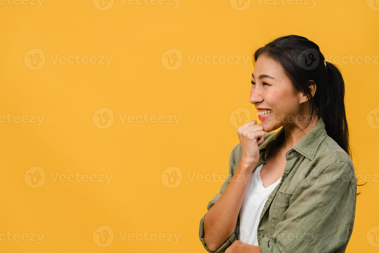 Young Asia lady feel happiness with positive expression, joyful surprise funky, dressed in casual cloth isolated on yellow background. Happy adorable glad woman rejoices success. Facial expression. photo
