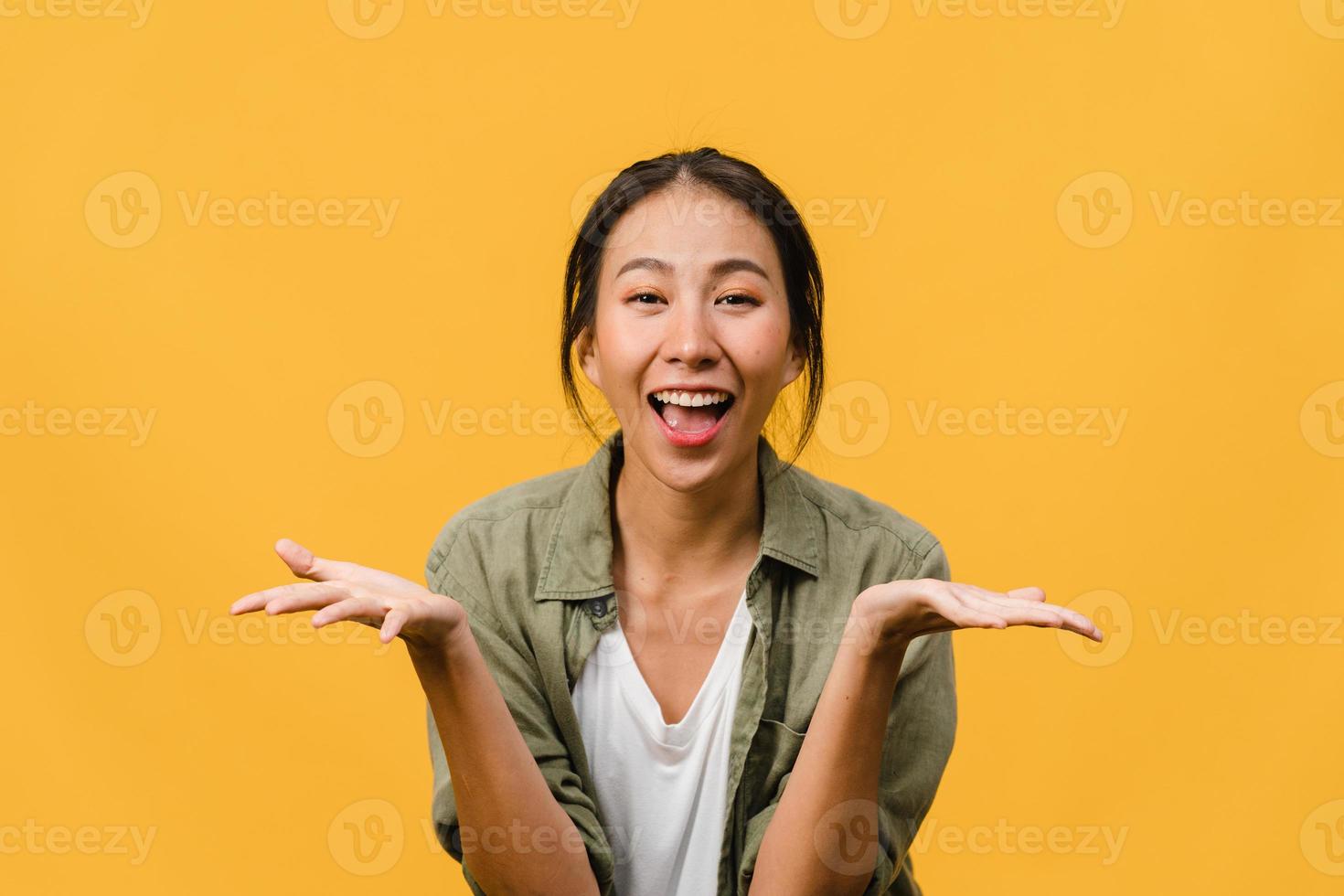 Young Asia lady feel happiness with positive expression, joyful surprise funky, dressed in casual cloth and looking at camera isolated on yellow background. Happy adorable glad woman rejoices success. photo