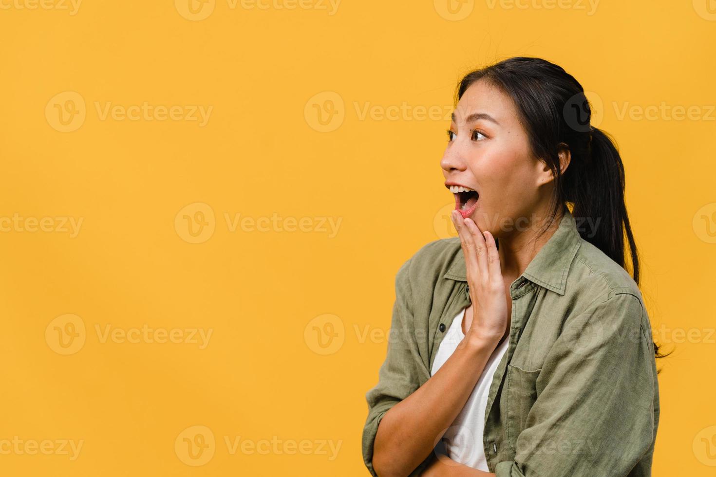 Young Asia lady feel happiness with positive expression, joyful surprise funky, dressed in casual cloth isolated on yellow background. Happy adorable glad woman rejoices success. Facial expression. photo