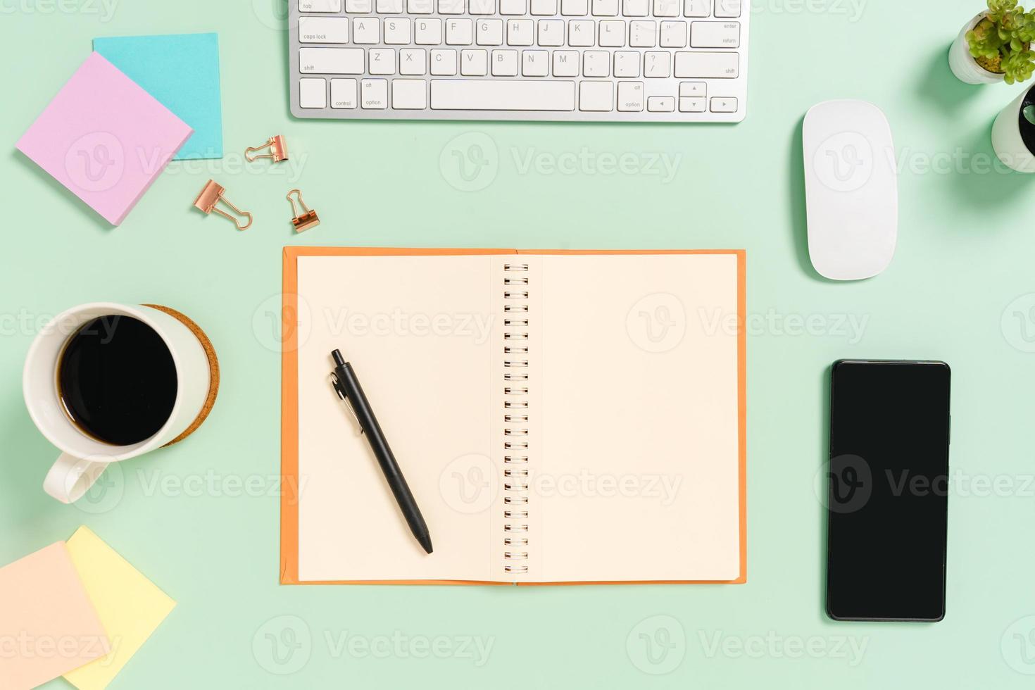 Creative flat lay photo of workspace desk. Top view office desk with keyboard, mouse and open mockup black notebook on pastel green color background. Top view mock up with copy space photography.