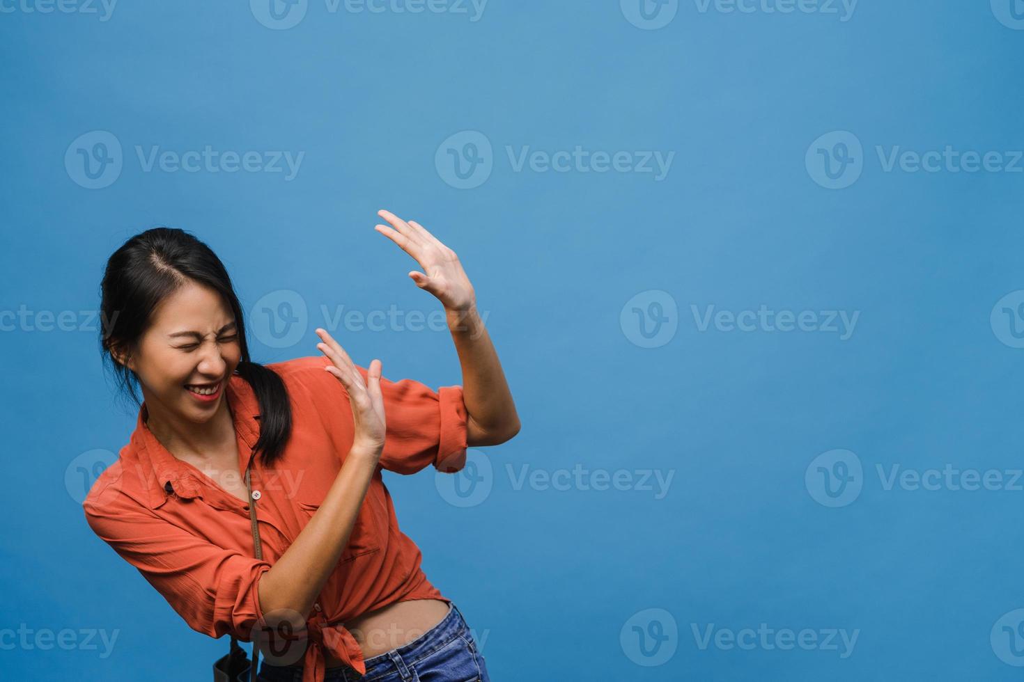 La joven dama de Asia siente felicidad con expresión positiva, alegre sorpresa funky, vestida con un paño informal aislado sobre fondo azul. feliz adorable mujer alegre se regocija con el éxito. expresión facial. foto