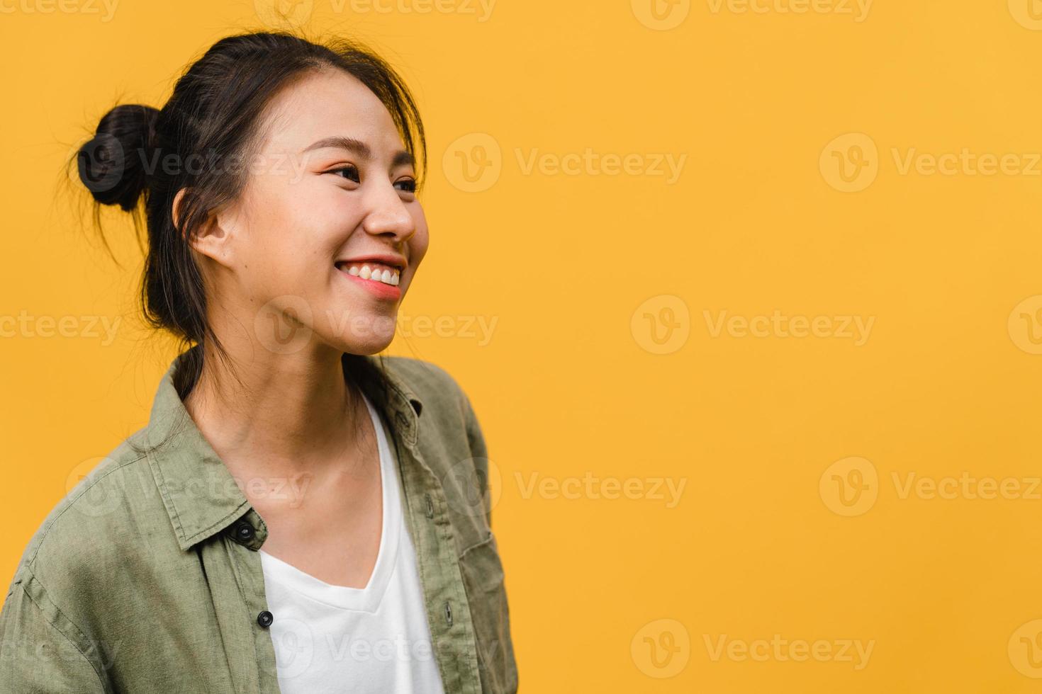 Retrato de joven asiática con expresión positiva, sonrisa amplia, vestida con ropa casual sobre fondo amarillo. feliz adorable mujer alegre se regocija con el éxito. concepto de expresión facial. foto