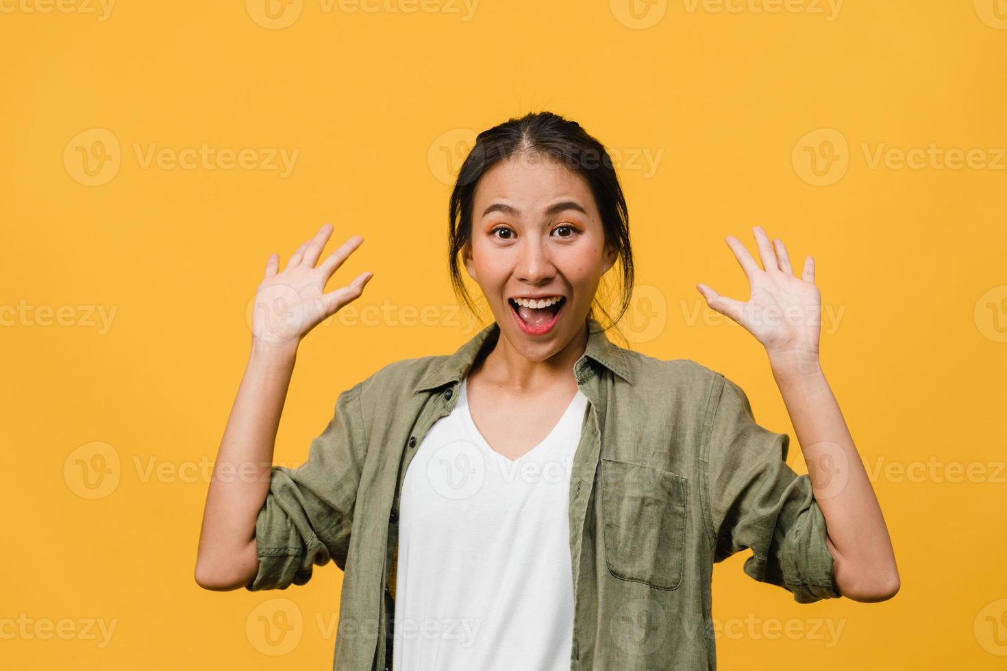 Young Asia lady feel happiness with positive expression, joyful surprise funky, dressed in casual cloth and looking at camera isolated on yellow background. Happy adorable glad woman rejoices success. photo