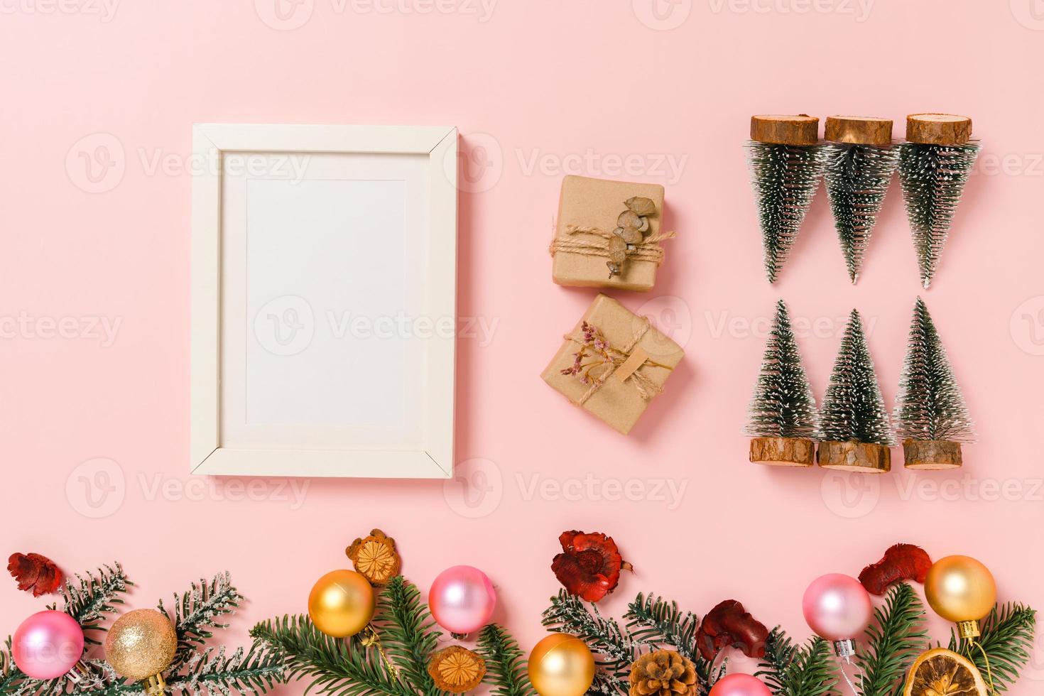 Minimal creative flat lay of winter christmas traditional composition and new year holiday season. Top view mockup black picture frames for text on pink background. Mock up and copy space photography. photo
