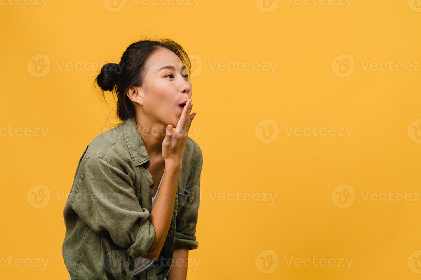 Young Asia lady feel happiness with positive expression, joyful surprise funky, dressed in casual cloth isolated on yellow background. Happy adorable glad woman rejoices success. Facial expression. photo