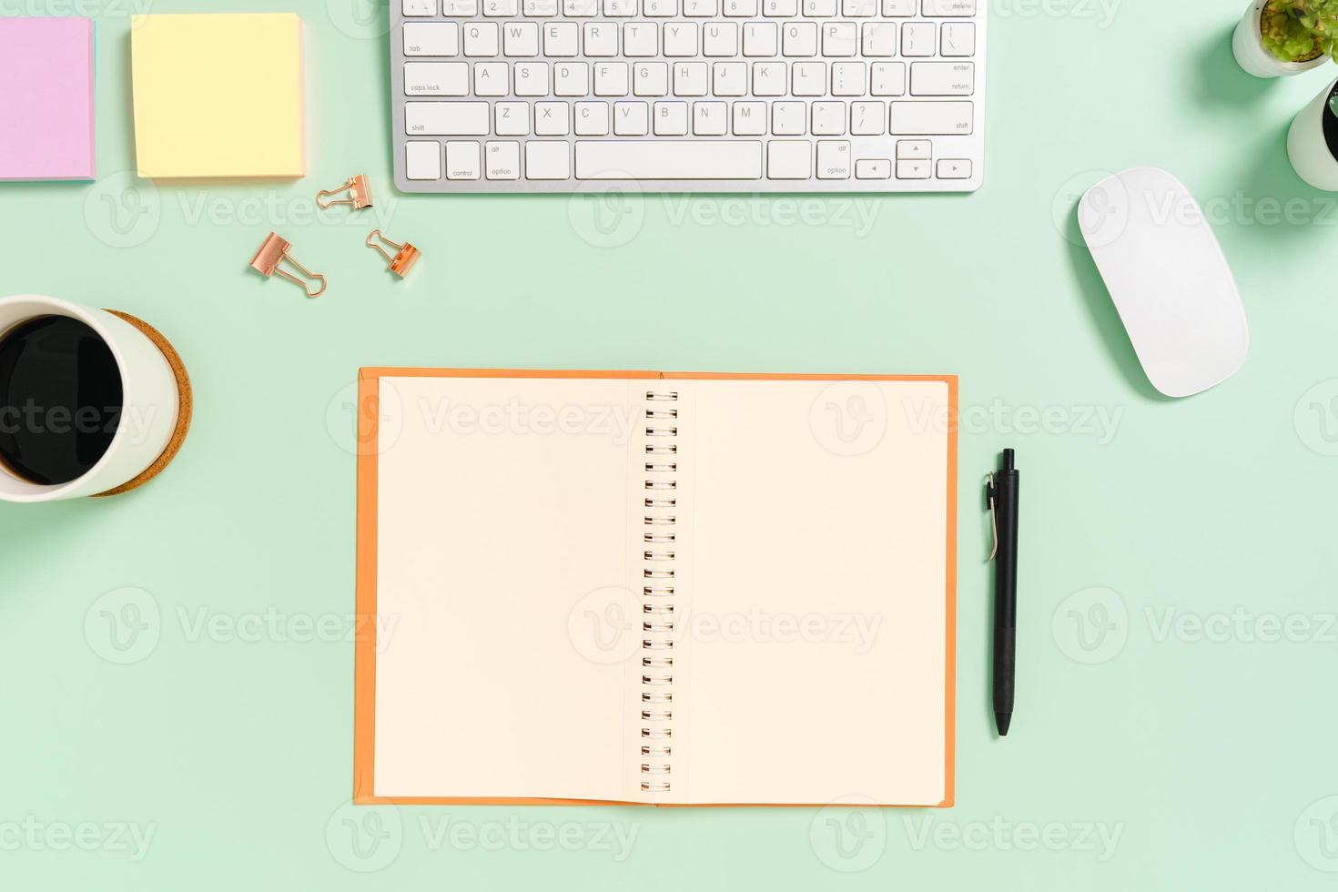 Creative flat lay photo of workspace desk. Top view office desk with keyboard, mouse and open mockup black notebook on pastel green color background. Top view mock up with copy space photography.