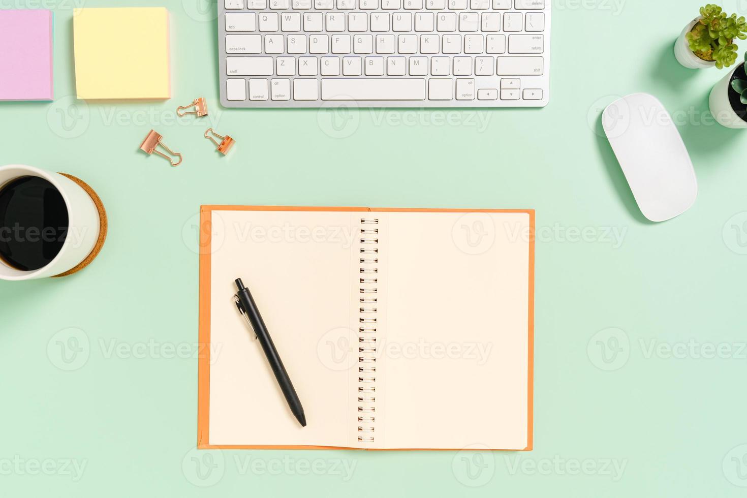 Creative flat lay photo of workspace desk. Top view office desk with keyboard, mouse and open mockup black notebook on pastel green color background. Top view mock up with copy space photography.