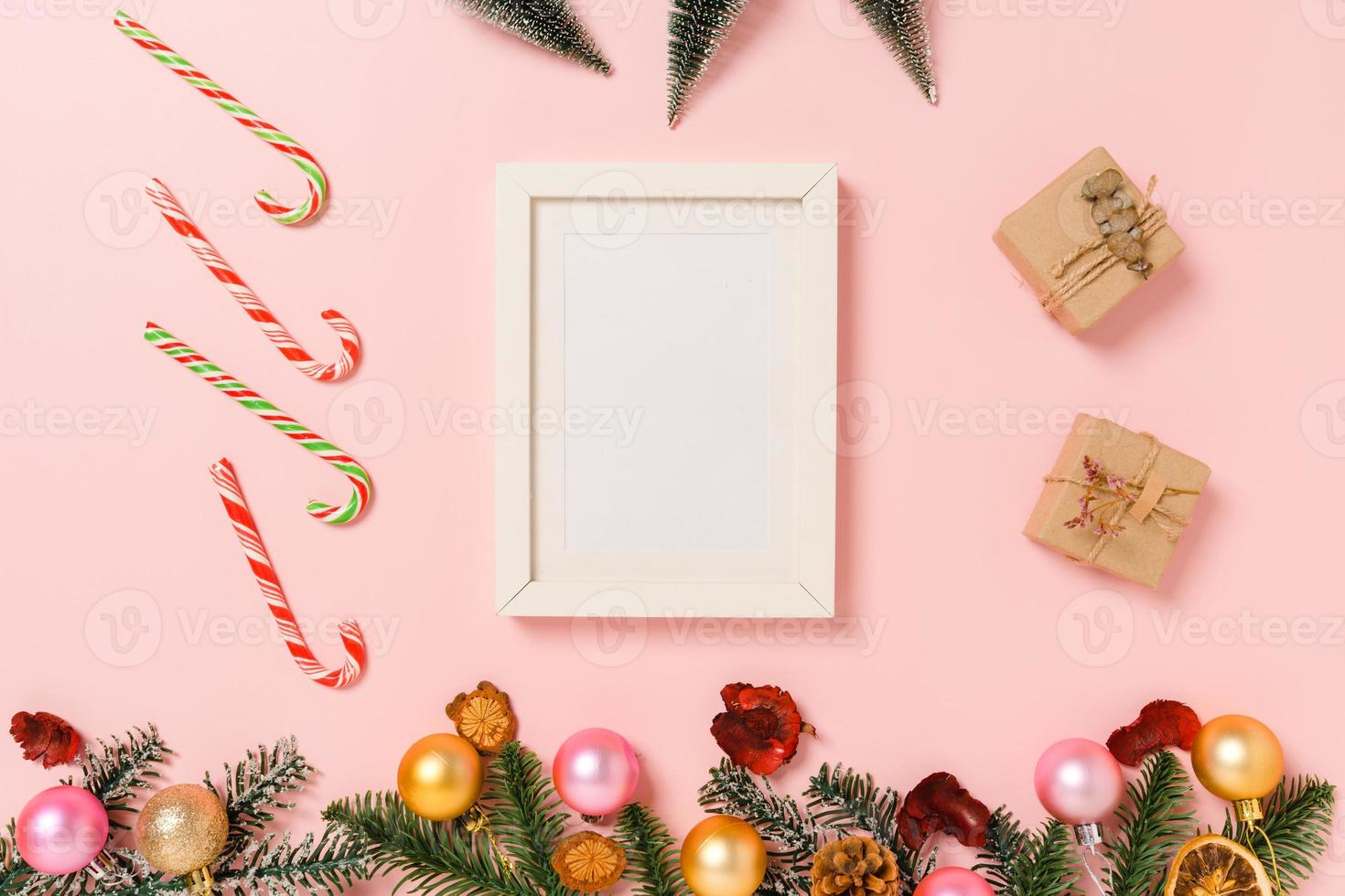 Minimal creative flat lay of winter christmas traditional composition and new year holiday season. Top view mockup black picture frames for text on pink background. Mock up and copy space photography. photo