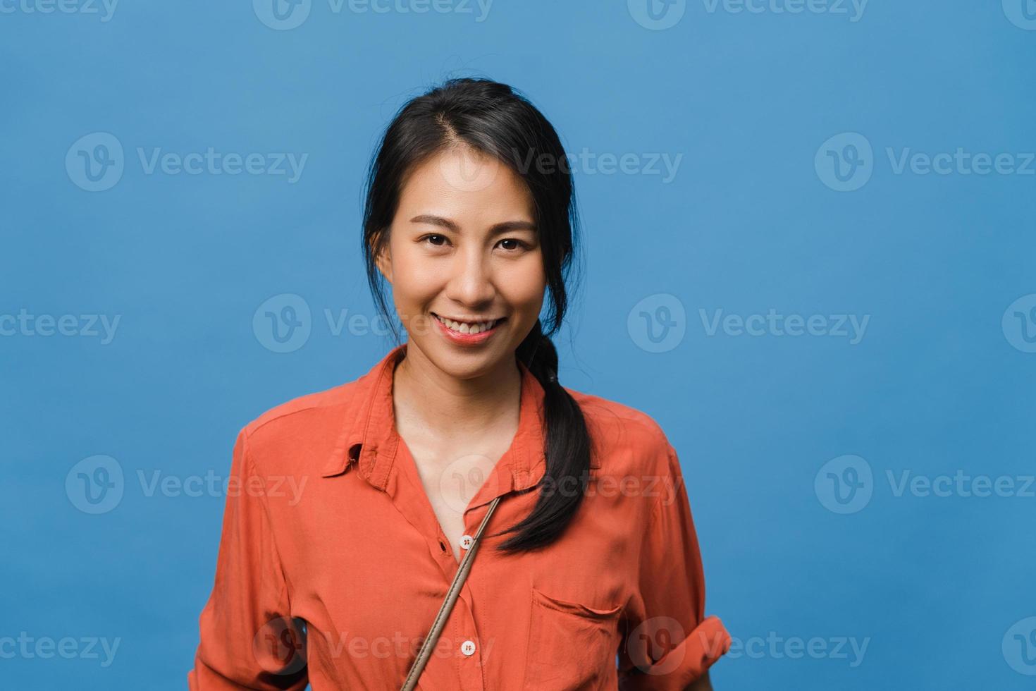 Young Asia lady with positive expression, smile broadly, dressed in casual clothing and looking at camera over blue background. Happy adorable glad woman rejoices success. Facial expression concept. photo