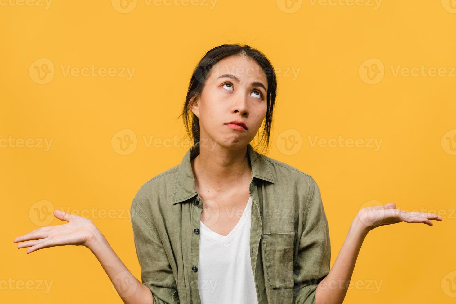 Retrato de joven asiática con expresión negativa, gritos emocionados, llorando emocionalmente enojado en ropa casual aislado sobre fondo amarillo con espacio de copia en blanco. concepto de expresión facial. foto