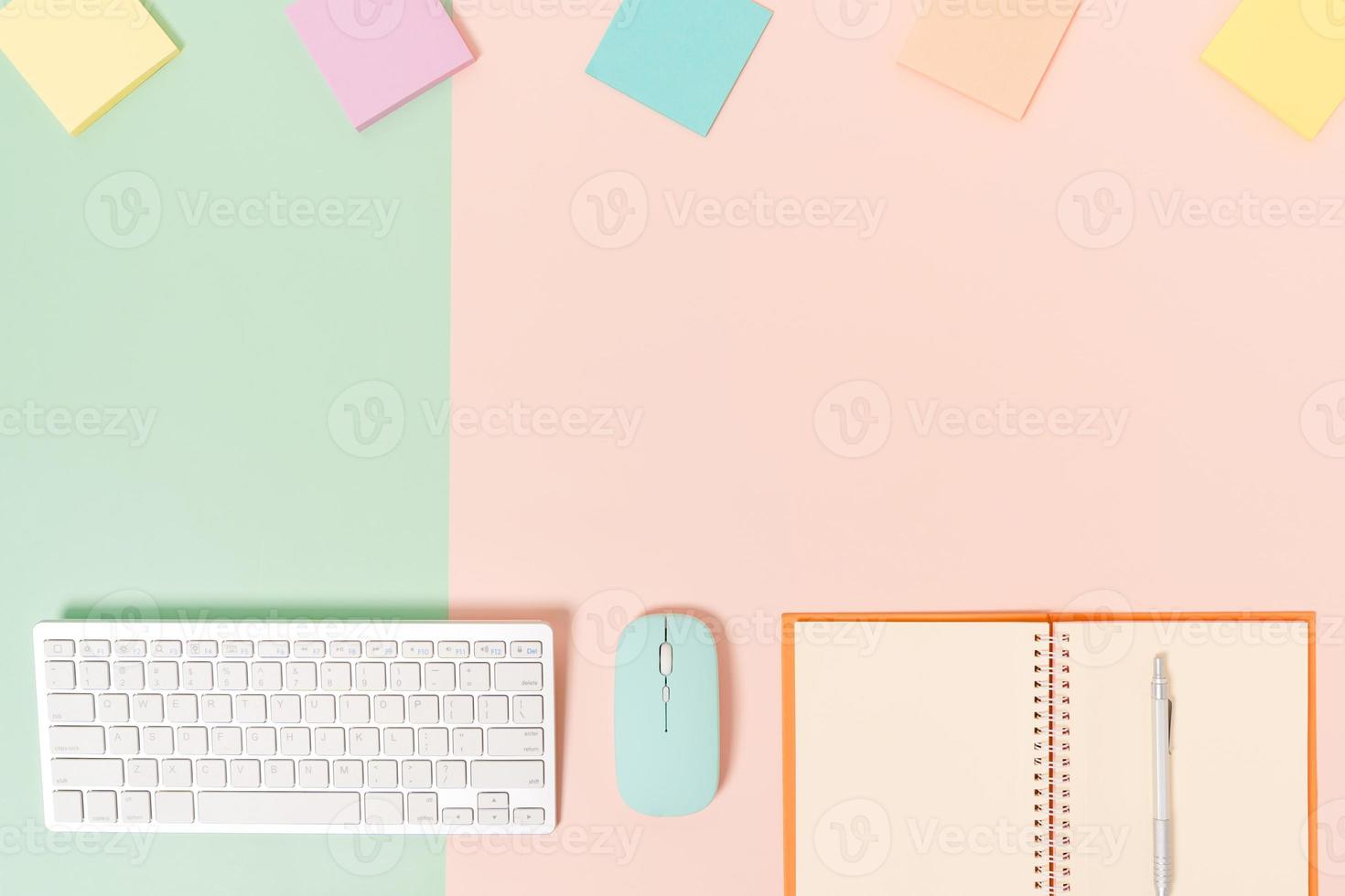 Creative flat lay photo of workspace desk. Top view office desk with keyboard, mouse and open mockup black notebook on pastel green pink color background. Top view mock up with copy space photography.