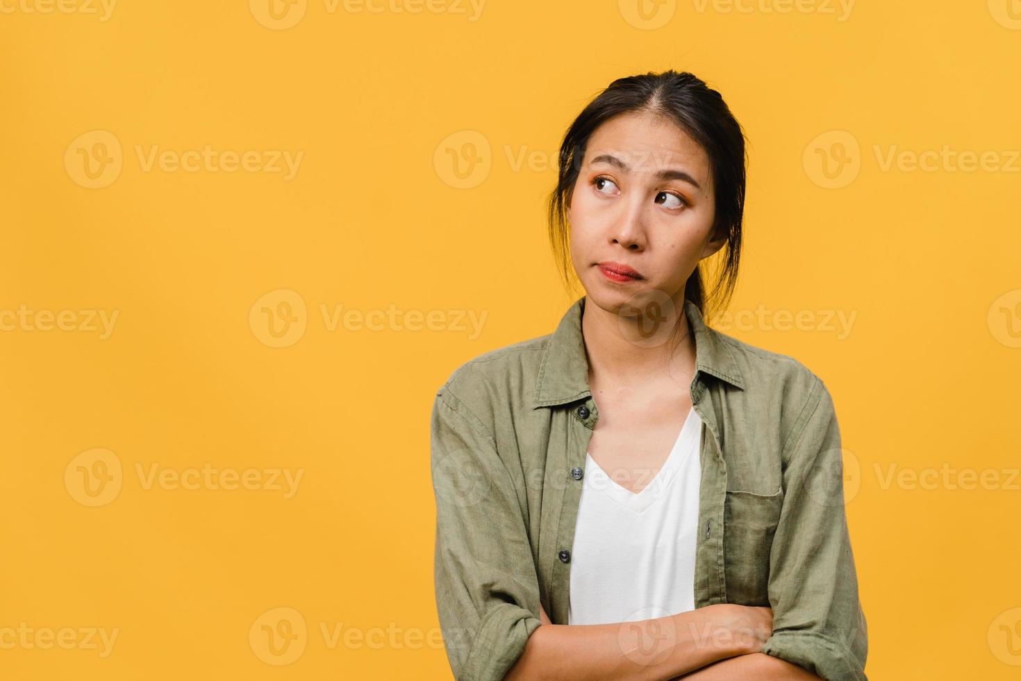 Retrato de joven asiática con expresión negativa, gritos emocionados, llorando emocionalmente enojado en ropa casual aislado sobre fondo amarillo con espacio de copia en blanco. concepto de expresión facial. foto