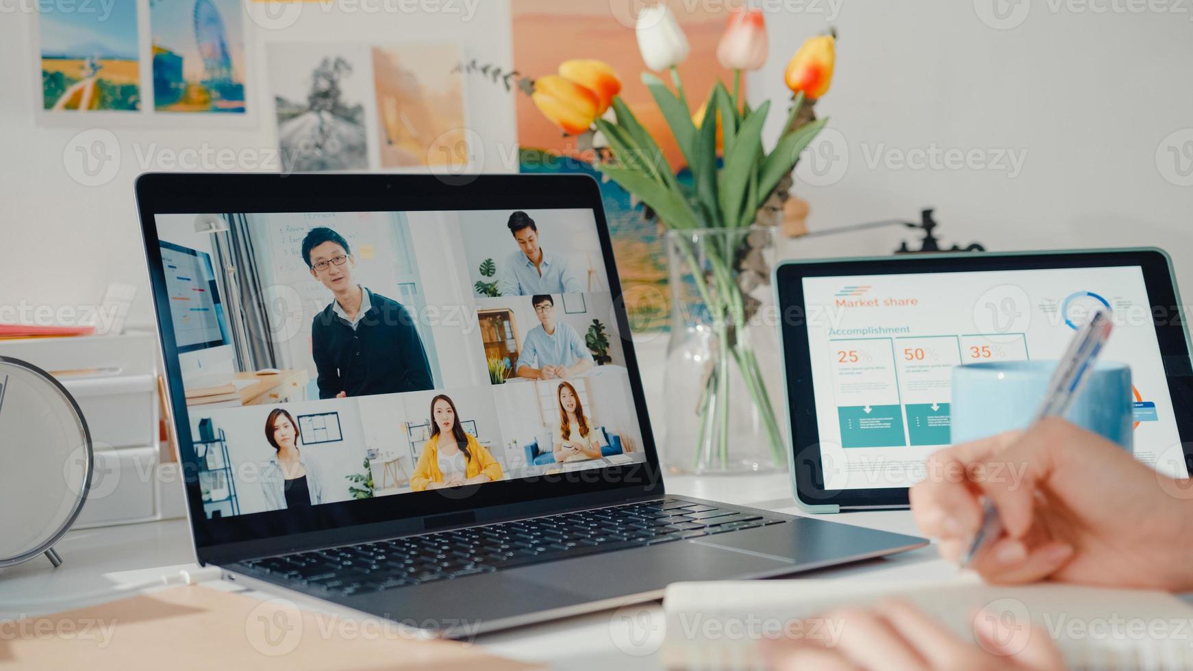 joven empleada de asia escucha al líder en la videollamada con diversos colegas multirraciales en línea con la computadora portátil en casa. la educación a distancia. alumna aprende en línea en casa, concepto de reunión en línea. foto