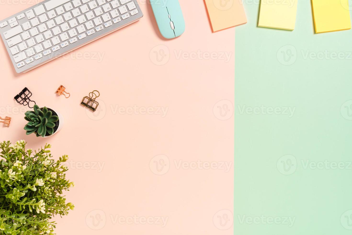 Minimal work space - Creative flat lay photo of workspace desk. Top view office desk with keyboard, mouse and adhesive note on pastel green pink color background. Top view with copy space photography.