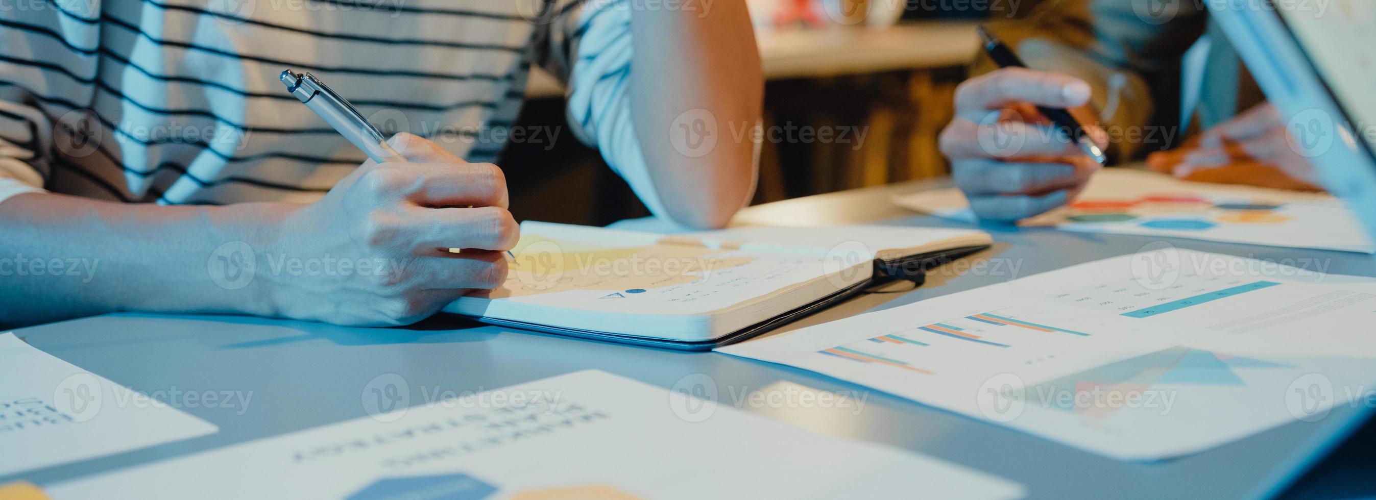 Asia businesspeople meeting plan analysis statistics brainstorm and header of team hold tablet graph chart and employee take note in home office night. Panoramic banner background with copy space. photo