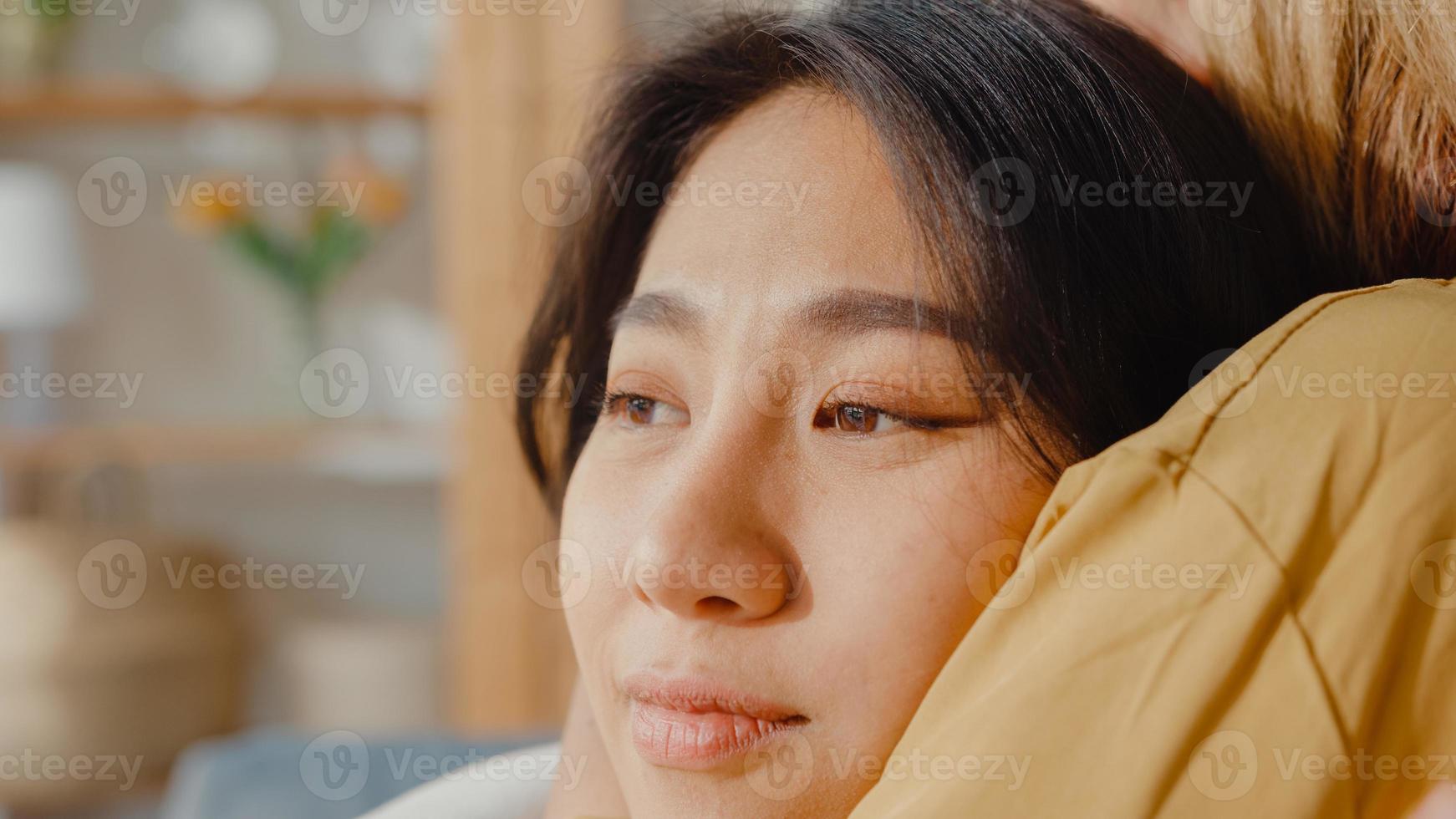 Sad young asian woman hug cuddle embracing with best friend in living room at home support each other with hard time with feel sick and bad, Relationship support concept. photo