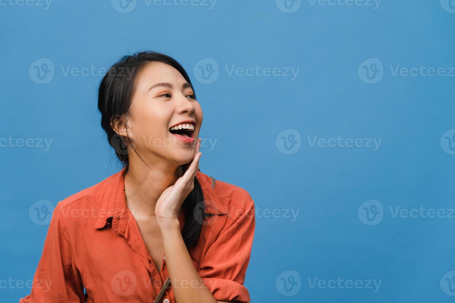 Retrato de una joven asiática con expresión positiva, una amplia sonrisa, vestida con ropa casual sobre fondo azul. feliz adorable mujer alegre se regocija con el éxito. concepto de expresión facial. foto