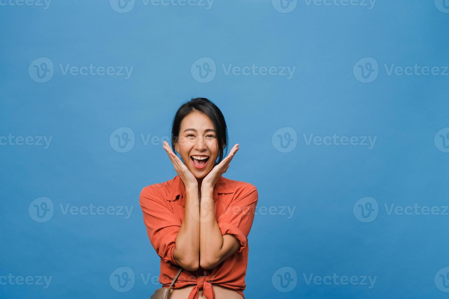 Young Asia lady with positive expression, smile broadly, dressed in casual clothing and looking at camera over blue background. Happy adorable glad woman rejoices success. Facial expression concept. photo