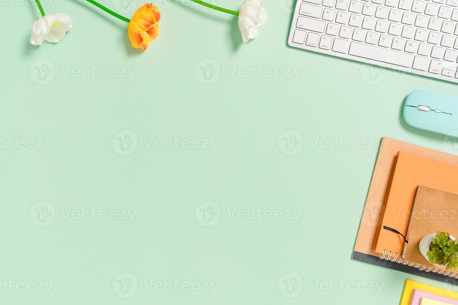 Minimal work space - Creative flat lay photo of workspace desk. Top view office desk with keyboard, mouse and notebook on pastel green color background. Top view with copy space, flat lay photography.