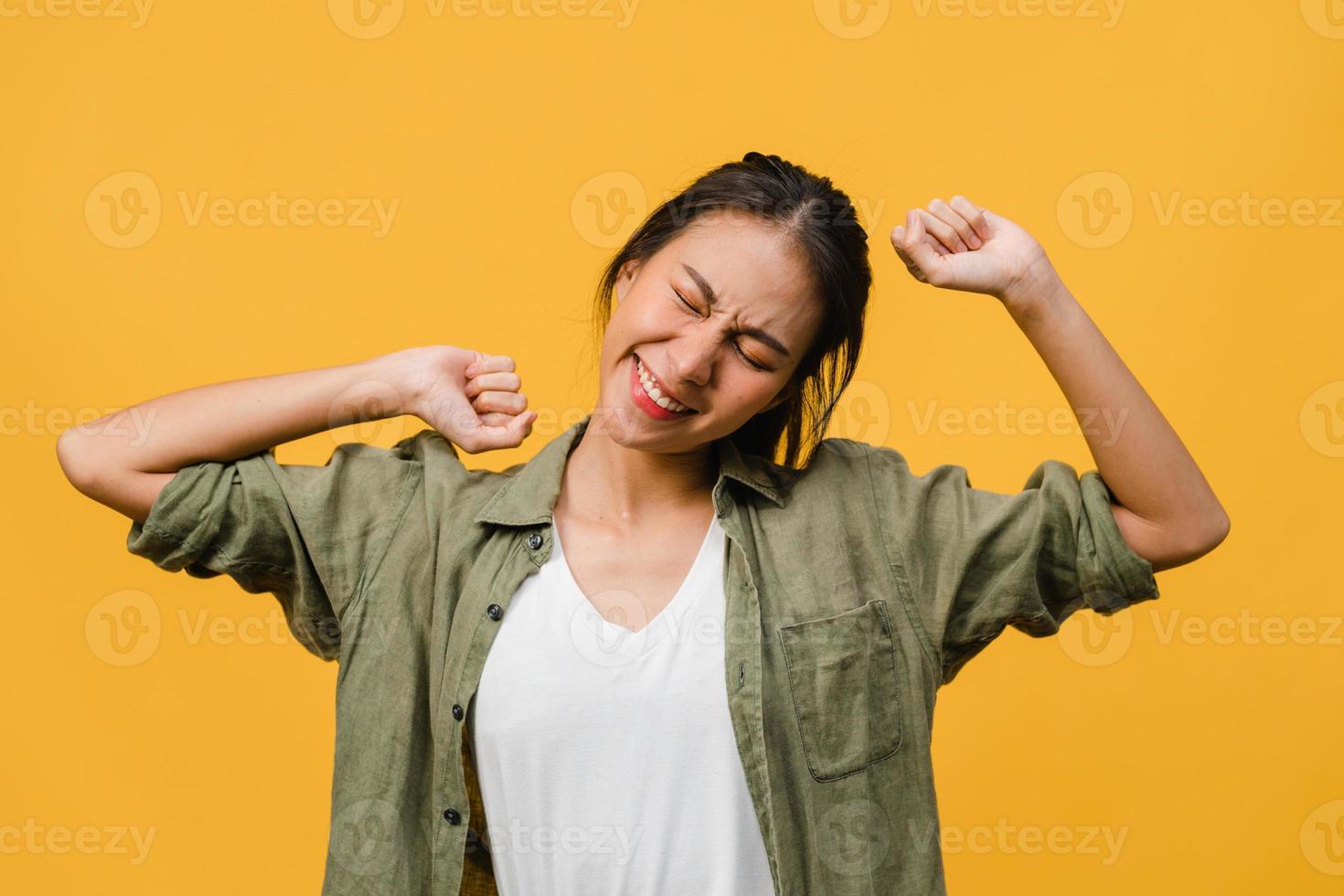 Young Asia lady with positive expression, joyful and exciting, dressed in casual cloth over yellow background with empty space. Happy adorable glad woman rejoices success. Facial expression concept. photo