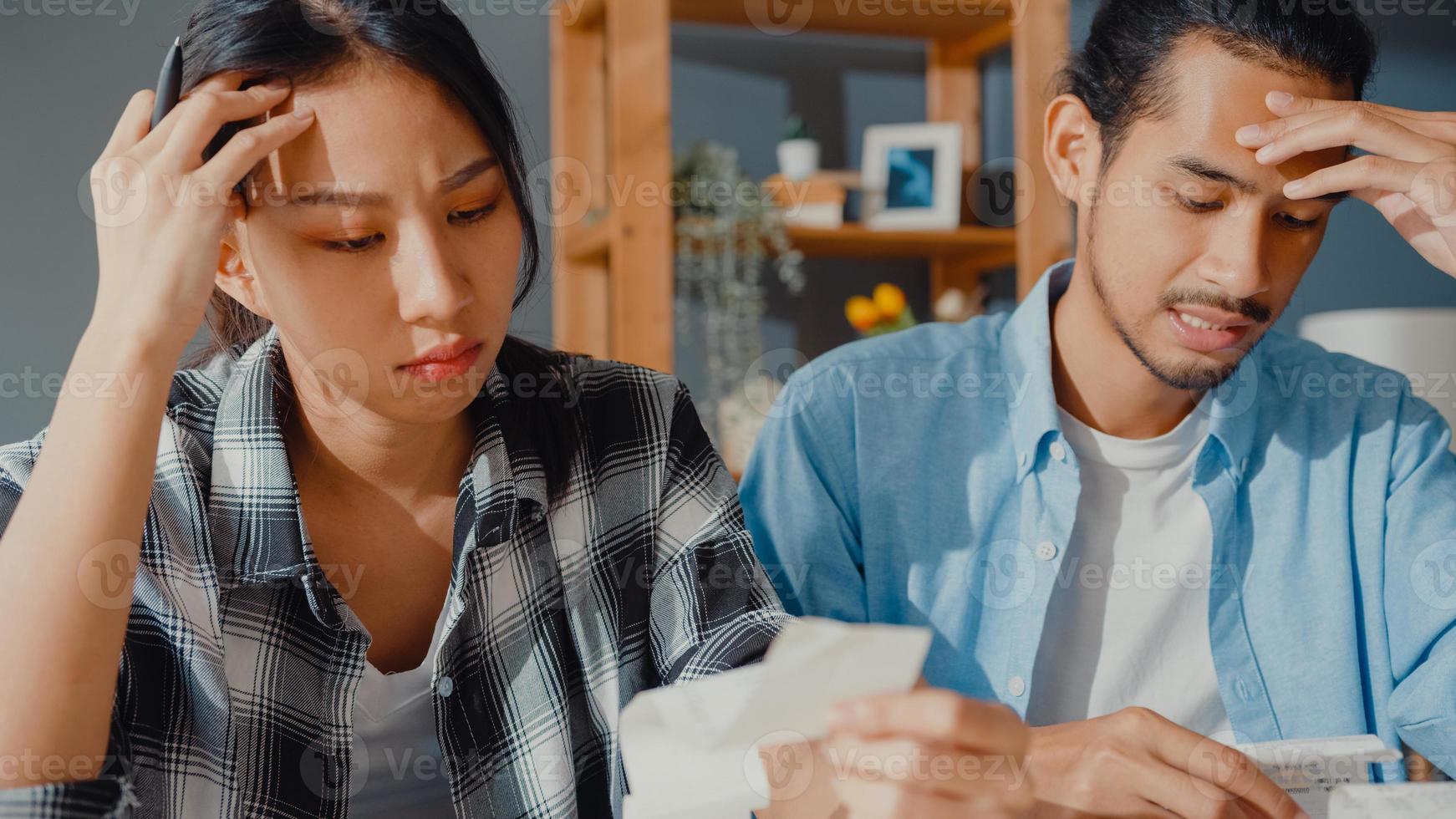 Stress asia couple man and woman use calculator for calculate family budget, debts, monthly expenses during financial economic crisis at home. marriage money trouble, Family budget planning concept. photo