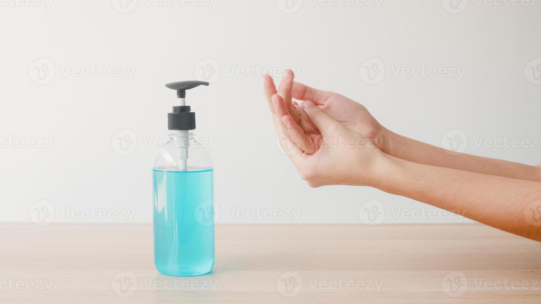 Asian woman using alcohol gel hand sanitizer wash hand for protect coronavirus. Female push alcohol bottle to clean hand for hygiene when social distancing stay at home and self quarantine time. photo