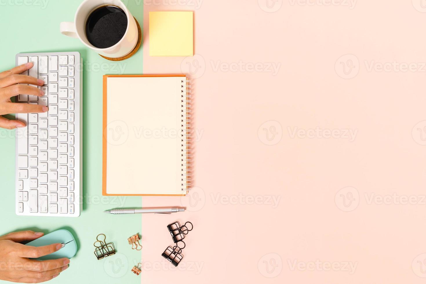 Creative flat lay photo of workspace desk. Top view office desk with keyboard, mouse and open mockup black notebook on pastel green pink color background. Top view mock up with copy space photography.