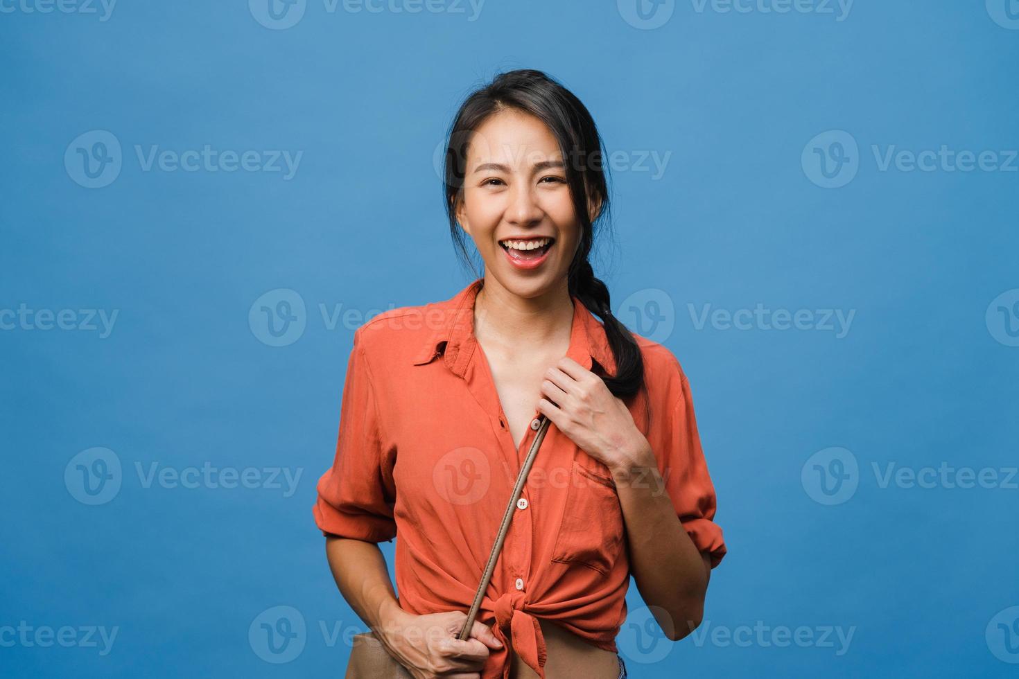 Young Asia lady with positive expression, smile broadly, dressed in casual clothing and looking at camera over blue background. Happy adorable glad woman rejoices success. Facial expression concept. photo