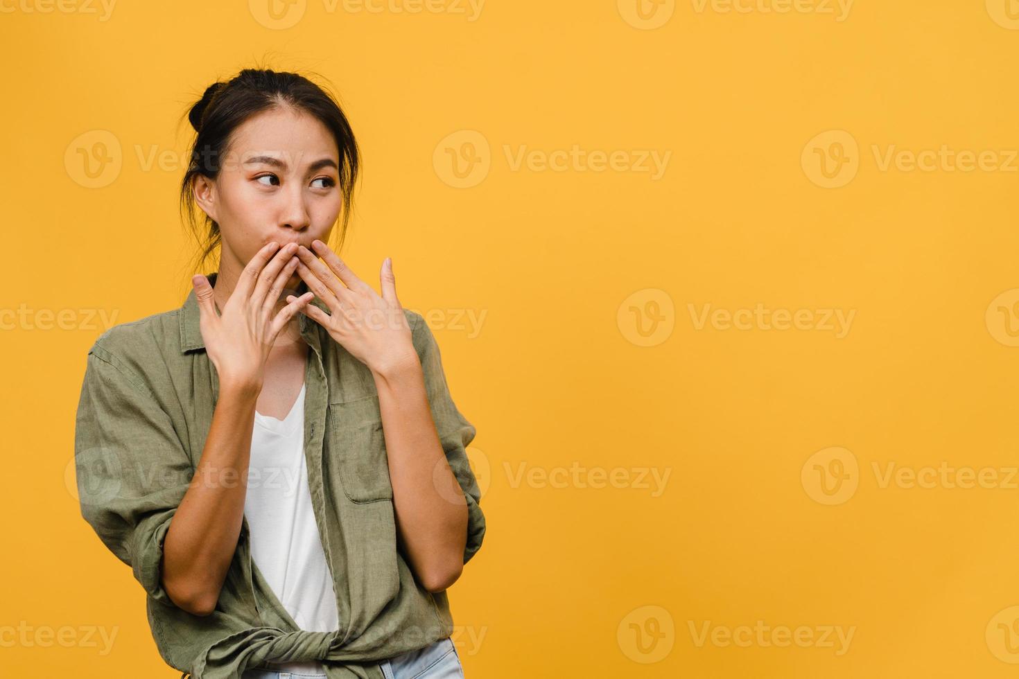 La joven dama de Asia siente felicidad con expresión positiva, alegre sorpresa funky, vestida con un paño casual aislado sobre fondo amarillo. feliz adorable mujer alegre se regocija con el éxito. expresión facial. foto