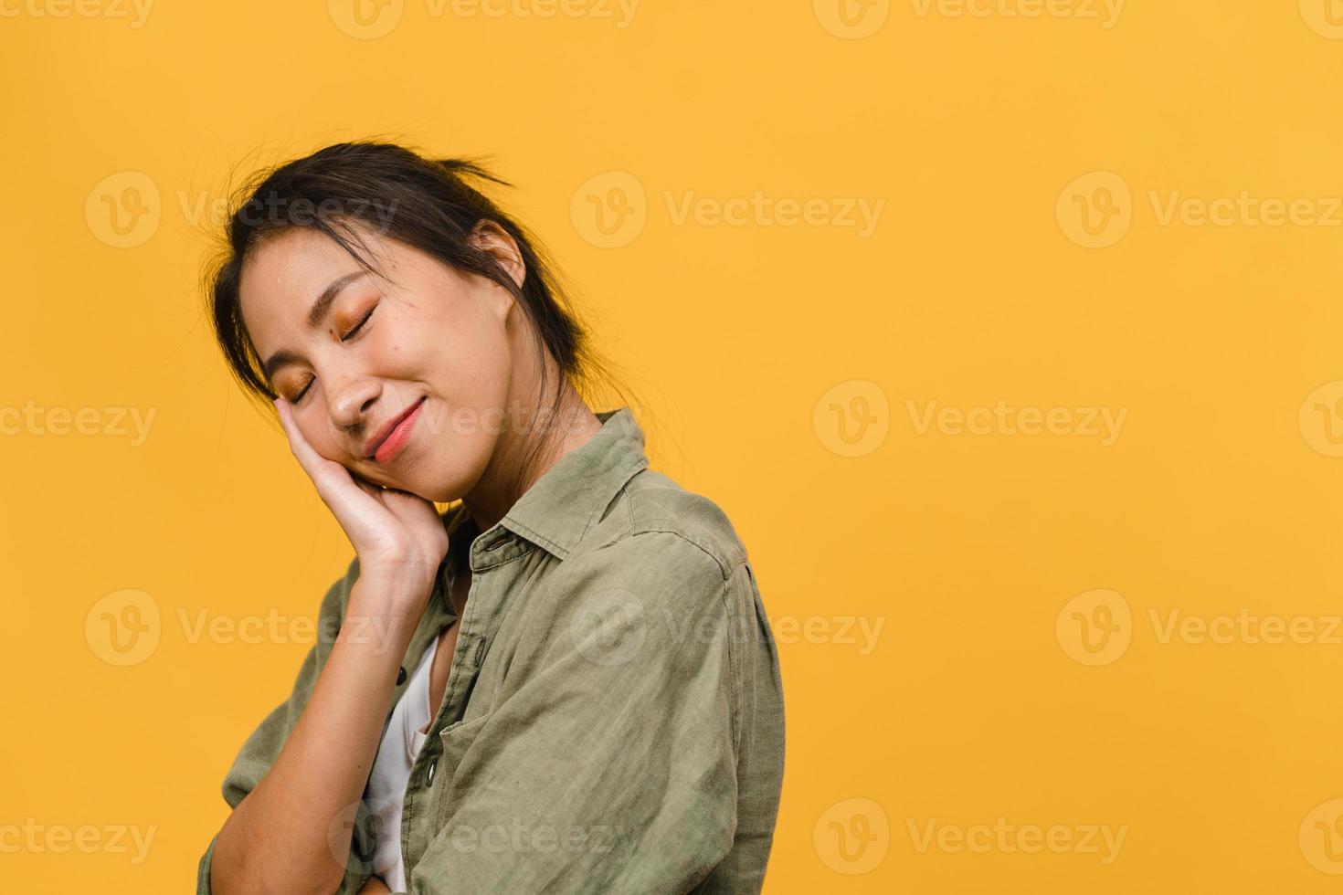 Portrait of young Asia lady with positive expression, smile broadly, dressed in casual clothing over yellow background. Happy adorable glad woman rejoices success. Facial expression concept. photo