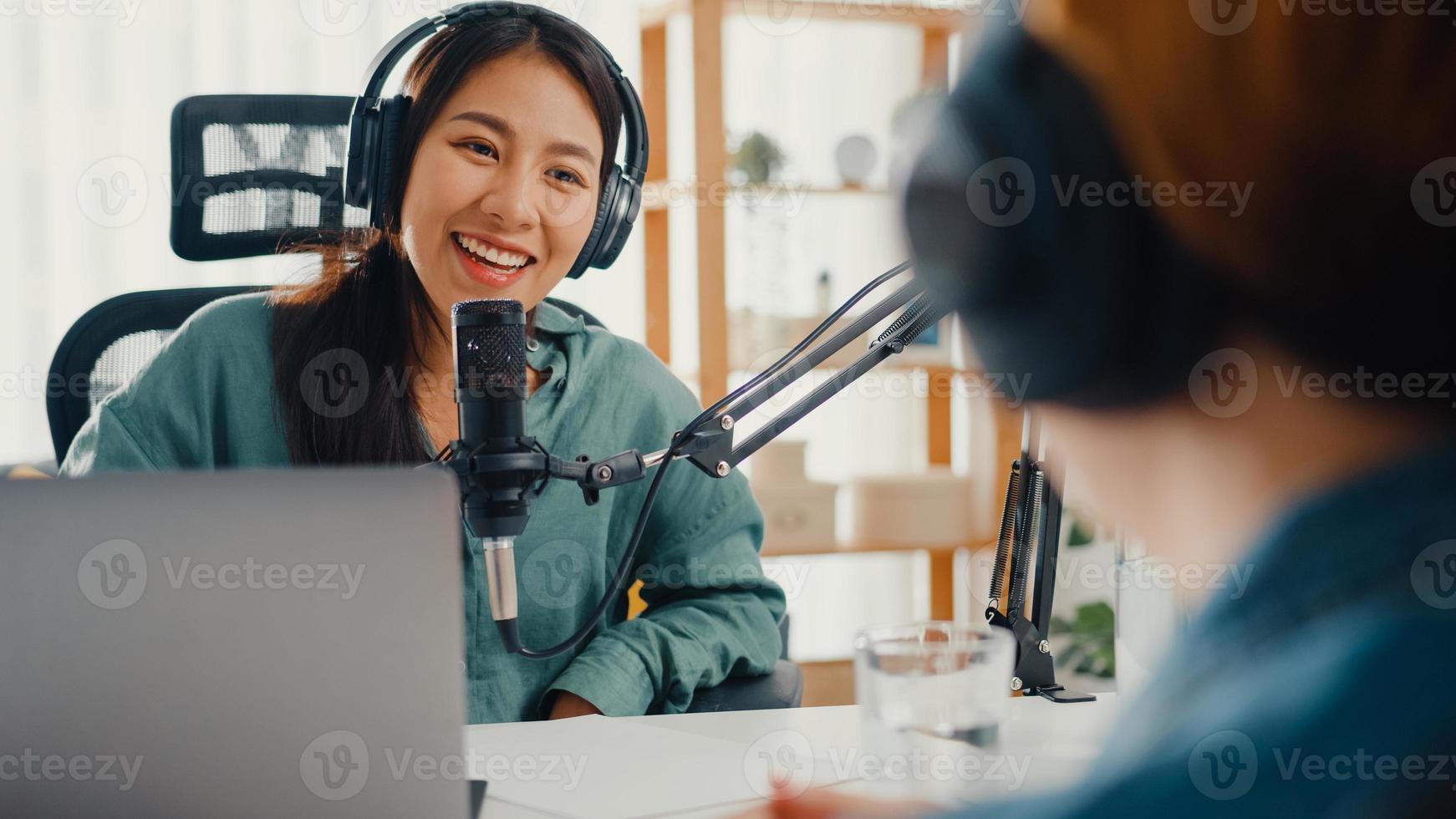 Asia girl radio host record podcast use microphone wear headphone interview celebrity guest content conversation talk and listen in her room. Audio podcast from home, Sound equipment concept. photo