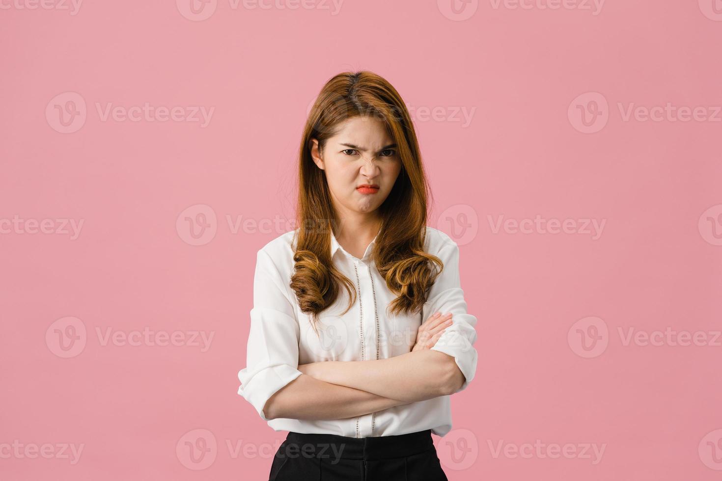 Jovencita asiática con expresión negativa, gritos emocionados, llorando enojado emocionalmente en ropa casual y mirando a cámara aislada sobre fondo rosa. feliz adorable mujer alegre se regocija con el éxito. foto