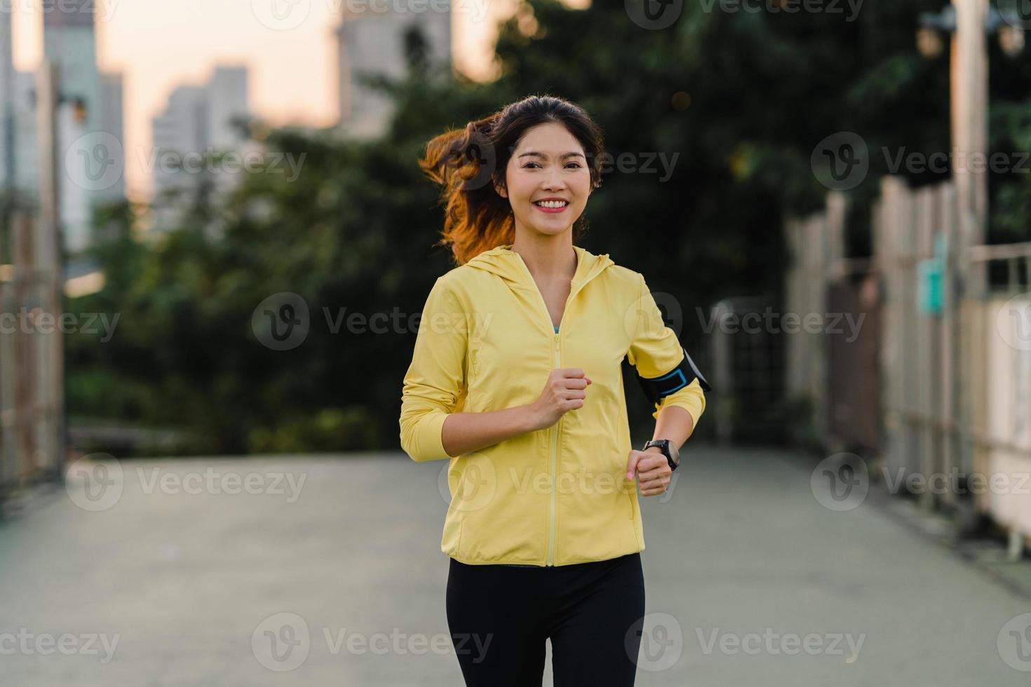 Señora hermosa joven atleta de Asia ejecutando ejercicios se resuelven en el entorno urbano. Jovencita japonesa vistiendo ropa deportiva en el puente de la pasarela temprano en la mañana. estilo de vida deportivo activo en la ciudad. foto