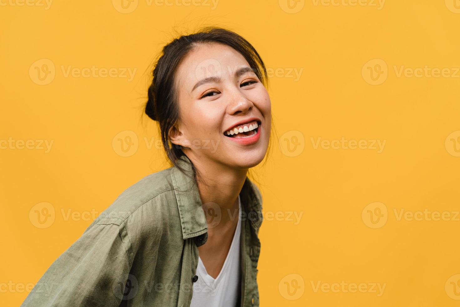 Young Asia lady with positive expression, smile broadly, dressed in casual clothing and looking at camera over yellow background. Happy adorable glad woman rejoices success. Facial expression concept. photo