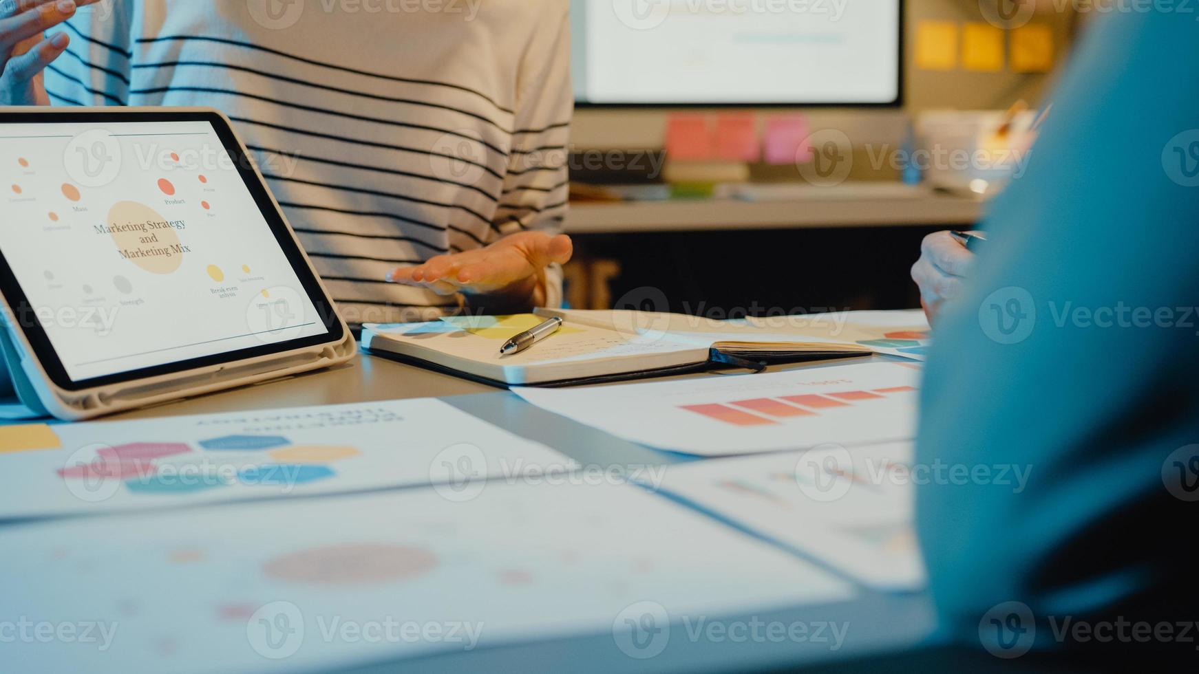 Asia businesspeople meeting plan analysis statistics brainstorm and header of team hold tablet point graph chart and employee take note in modern home office night. Finance strategy success concept. photo