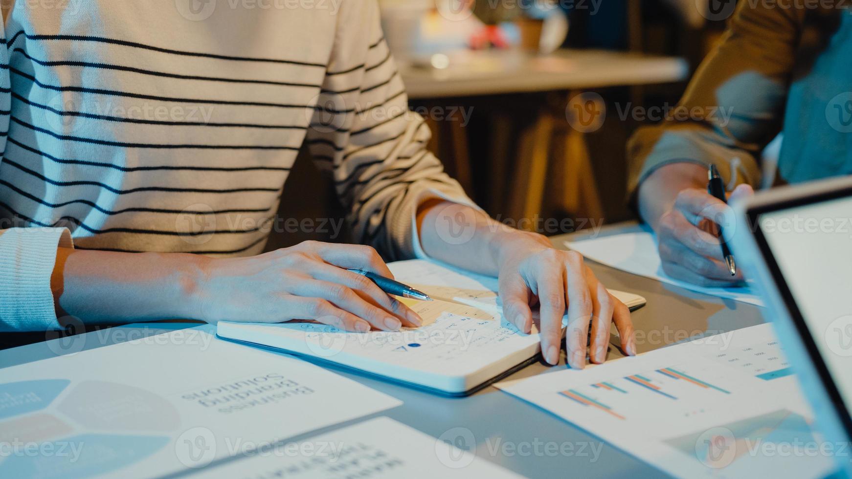 Reunión de empresarios de Asia, análisis de estadísticas, lluvia de ideas y encabezado del equipo mantenga el gráfico de puntos de la tableta y el empleado tome nota en la noche moderna de la oficina en casa. concepto de éxito de la estrategia financiera. foto