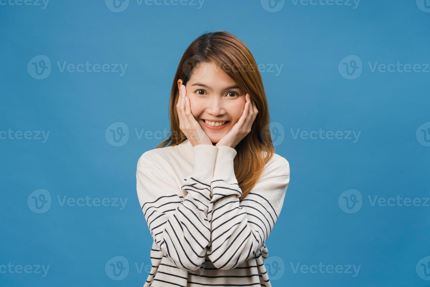 joven asiática con expresión positiva, sonrisa amplia, vestida con ropa informal y mirar a cámara aislada sobre fondo azul. feliz adorable mujer alegre se regocija con el éxito. concepto de expresión facial. foto