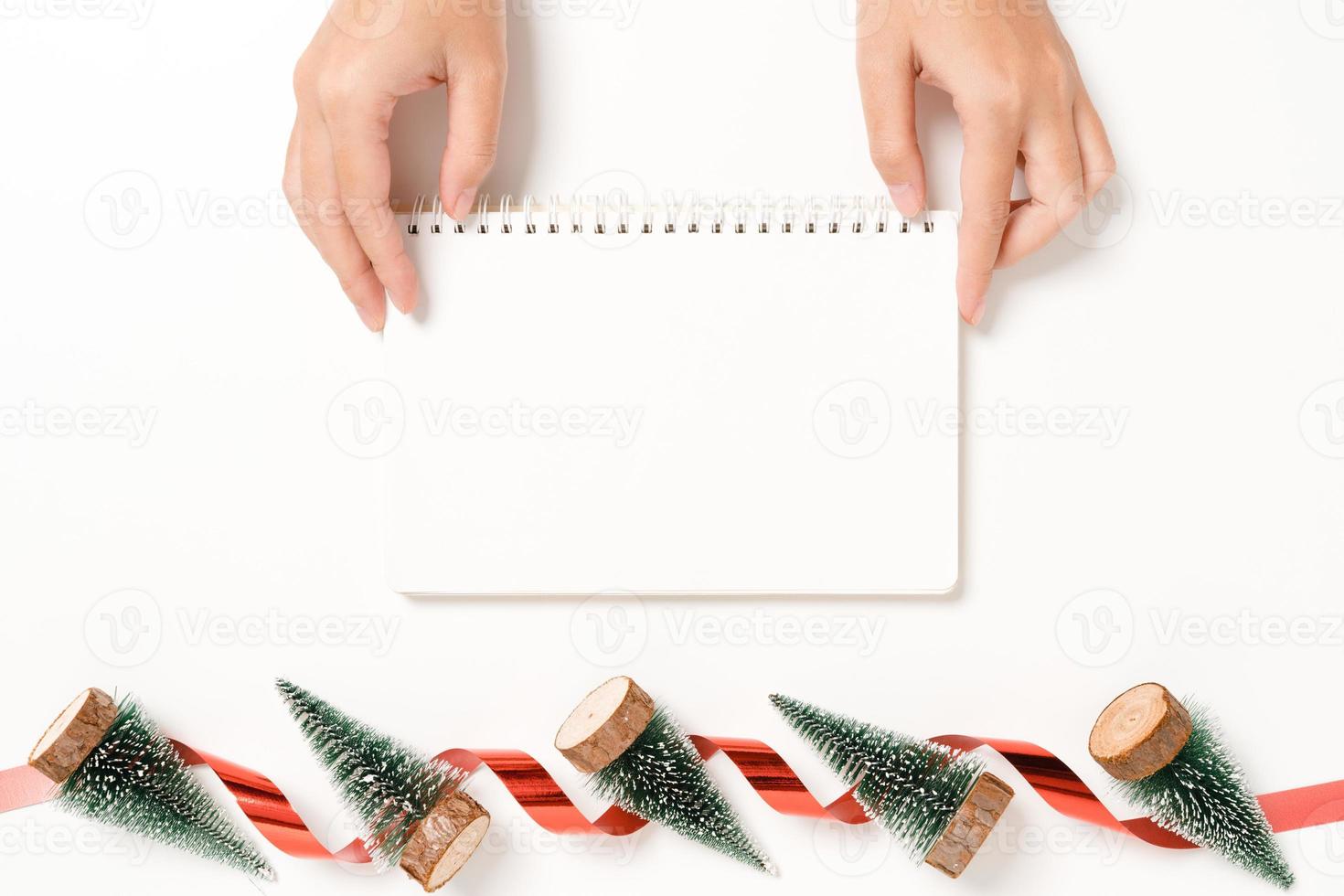 Minimal creative flat lay of winter christmas traditional composition and new year holiday season. Top view open mockup black notebook for text on white background. Mock up and copy space photography. photo